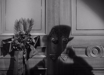 Movie still from “The Magnificent Ambersons” (1942), directed by Robert Wise – A black - and - white photo of a door and a potted plant; Close Up shot, Low angle