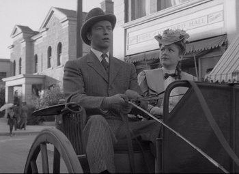 Movie still from “The Magnificent Ambersons” (1942), directed by Robert Wise – A man and a woman riding in a horse drawn carriage down a street; Medium shot, Low angle