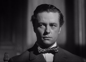 Movie still from “The Magnificent Ambersons” (1942), directed by Robert Wise – A man in a suit and a bow tie; Close Up shot, Low angle