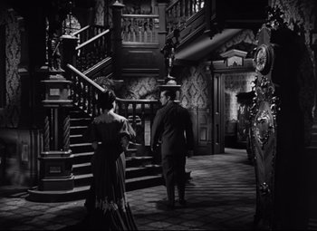 Movie still from “The Magnificent Ambersons” (1942), directed by Robert Wise – A man and a woman walking down a staircase; Wide shot, High angle