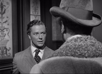 Movie still from “The Magnificent Ambersons” (1942), directed by Robert Wise – A black and white photo of a man in a suit and tie looking at another man in a hat; Close Up shot, Over the shoulder angle