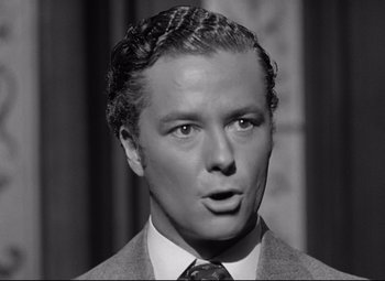 Movie still from “The Magnificent Ambersons” (1942), directed by Robert Wise – A man in a suit and tie looking at the camera; Close Up shot, Low angle