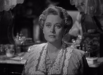 Movie still from “The Magnificent Ambersons” (1942), directed by Robert Wise – An old photo of a woman in a lace dress looking at the camera; Close Up shot, Over the shoulder angle