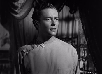 Movie still from “The Magnificent Ambersons” (1942), directed by Robert Wise – A man wearing a shirt and tie in a black and white photo; Close Up shot, Low angle