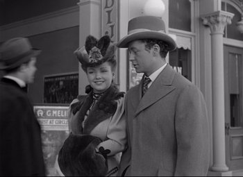 Movie still from “The Magnificent Ambersons” (1942), directed by Robert Wise – A man and a woman standing next to each other on the street; Medium shot, Low angle