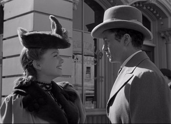 Movie still from “The Magnificent Ambersons” (1942), directed by Robert Wise – A man and a woman standing next to each other on the street; Medium shot, Low angle