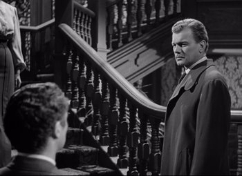 Movie still from “The Magnificent Ambersons” (1942), directed by Robert Wise – A black and white photo of a man standing on the stairs; Medium shot, Low angle
