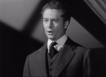 Movie still from “The Magnificent Ambersons” (1942), directed by Robert Wise – Black and white photograph of a man wearing a suit and tie; Close Up shot, Low angle