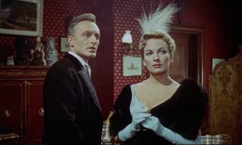 Movie still from “The Man Who Could Cheat Death” (1959), directed by Terence Fisher – A man and a woman standing next to each other in a room; Medium shot, Low angle