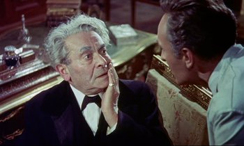 Movie still from “The Man Who Could Cheat Death” (1959), directed by Terence Fisher – An older man wearing a suit and tie talking to a younger man; Close Up shot, Over the shoulder angle