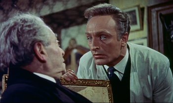 Movie still from “The Man Who Could Cheat Death” (1959), directed by Terence Fisher – An older man and a younger man looking at each other in a room; Close Up shot, Over the shoulder angle