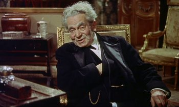 Movie still from “The Man Who Could Cheat Death” (1959), directed by Terence Fisher – An older man sitting in a chair in a room; Medium shot, High angle