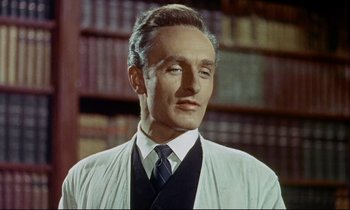 Movie still from “The Man Who Could Cheat Death” (1959), directed by Terence Fisher – A man wearing a white shirt and a tie in front of a book shelf; Close Up shot, Low angle