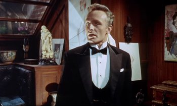 Movie still from “The Man Who Could Cheat Death” (1959), directed by Terence Fisher – A person wearing a suit and tie; Medium shot, Low angle