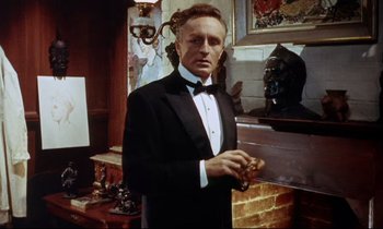 Movie still from “The Man Who Could Cheat Death” (1959), directed by Terence Fisher – A man in a tuxedo standing in front of a fireplace; Medium shot, Low angle