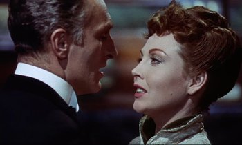 Movie still from “The Man Who Could Cheat Death” (1959), directed by Terence Fisher – An older man standing next to an older woman; Close Up shot, Over the shoulder angle