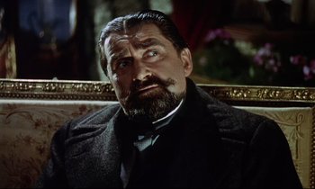 Movie still from “The Man Who Could Cheat Death” (1959), directed by Terence Fisher – A person wearing a suit and beard; Close Up shot, Over the shoulder angle