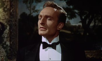 Movie still from “The Man Who Could Cheat Death” (1959), directed by Terence Fisher – A person wearing a suit and bow tie; Close Up shot, Low angle