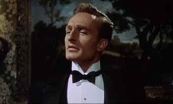 Movie still from “The Man Who Could Cheat Death” (1959), directed by Terence Fisher – A person wearing a suit and bow tie; Close Up shot, Low angle
