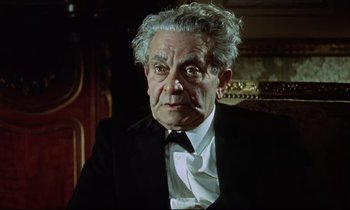 Movie still from “The Man Who Could Cheat Death” (1959), directed by Terence Fisher – An older man wearing a suit and tie; Close Up shot, High angle