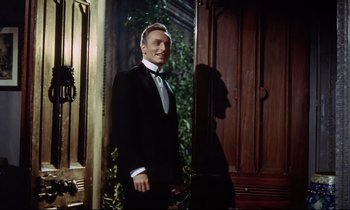 Movie still from “The Man Who Could Cheat Death” (1959), directed by Terence Fisher – A man in a tuxedo standing in front of a door way; Medium shot, Low angle