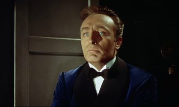 Movie still from “The Man Who Could Cheat Death” (1959), directed by Terence Fisher – A person wearing a suit and bow tie; Close Up shot, Low angle