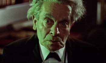 Movie still from “The Man Who Could Cheat Death” (1959), directed by Terence Fisher – An older man in a suit and tie looking at the camera; Close Up shot, Low angle