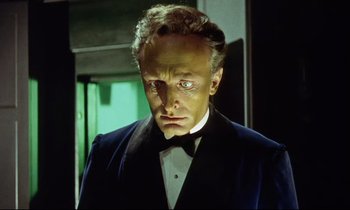 Movie still from “The Man Who Could Cheat Death” (1959), directed by Terence Fisher – A person wearing a suit and tie; Close Up shot, Low angle