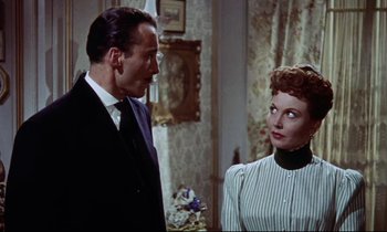 Movie still from “The Man Who Could Cheat Death” (1959), directed by Terence Fisher – A man and a woman standing next to each other in a room; Medium shot, Low angle