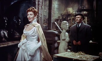 Movie still from “The Man Who Could Cheat Death” (1959), directed by Terence Fisher – A man and a woman standing next to a statue; Medium shot, Over the shoulder angle