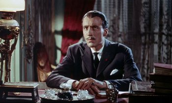 Movie still from “The Man Who Could Cheat Death” (1959), directed by Terence Fisher – A man sitting at a dinner table with his hands folded over his face; Close Up shot, Low angle