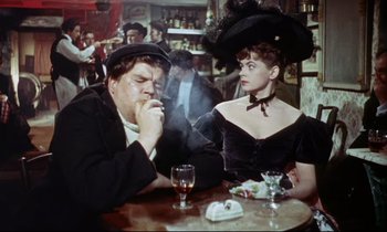 Movie still from “The Man Who Could Cheat Death” (1959), directed by Terence Fisher – A man and a woman sitting at a table smoking; Medium shot, High angle