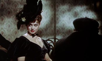 Movie still from “The Man Who Could Cheat Death” (1959), directed by Terence Fisher – A woman in a black dress and a black hat; Close Up shot, Over the shoulder angle
