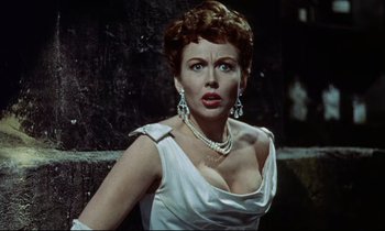 Movie still from “The Man Who Could Cheat Death” (1959), directed by Terence Fisher – A woman in a white dress with a necklace and earrings; Close Up shot, Low angle