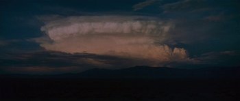 Movie still from “The Man Who Fell to Earth” (1976), directed by Nicolas Roeg – A dark cloudy sky over a mountain range; Extreme Wide shot, Low angle