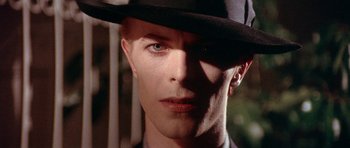 Movie still from “The Man Who Fell to Earth” (1976), directed by Nicolas Roeg – A person wearing a hat; Close Up shot, Over the shoulder angle