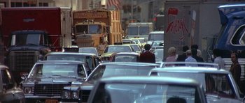 Movie still from “The Man Who Fell to Earth” (1976), directed by Nicolas Roeg – A busy street filled with lots of traffic; Extreme Wide shot, Over the shoulder angle
