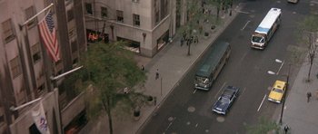 Movie still from “The Man Who Fell to Earth” (1976), directed by Nicolas Roeg – An aerial view of a city street with a bus and people walking; Extreme Wide shot, High angle