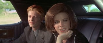 Movie still from “The Man Who Fell to Earth” (1976), directed by Nicolas Roeg – A man and a woman sitting next to each other in a car; Close Up shot, Over the shoulder angle