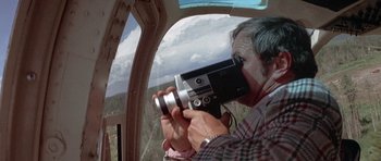 Movie still from “The Man Who Fell to Earth” (1976), directed by Nicolas Roeg – An older man taking a picture from inside a helicopter; Close Up shot, Low angle
