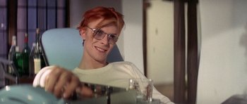 Movie still from “The Man Who Fell to Earth” (1976), directed by Nicolas Roeg – A man with red hair sitting in front of a mirror; Close Up shot, Over the shoulder angle