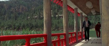 Movie still from “The Man Who Fell to Earth” (1976), directed by Nicolas Roeg – A view of a body of water through a red fence; Extreme Wide shot, High angle