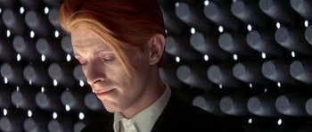 Movie still from “The Man Who Fell to Earth” (1976), directed by Nicolas Roeg – A person wearing a suit and tie; Close Up shot, Low angle