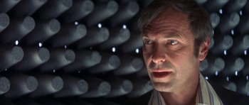 Movie still from “The Man Who Fell to Earth” (1976), directed by Nicolas Roeg – A person in front of lights; Close Up shot, Low angle