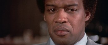 Movie still from “The Man Who Fell to Earth” (1976), directed by Nicolas Roeg – A person looking at the camera; Close Up shot, Low angle