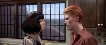 Movie still from “The Man Who Fell to Earth” (1976), directed by Nicolas Roeg – A man and a woman face to face in front of a window; Close Up shot, Over the shoulder angle