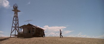 Movie still from “The Man Who Fell to Earth” (1976), directed by Nicolas Roeg – Two men in cowboy hats walking on the beach; Extreme Wide shot, Low angle