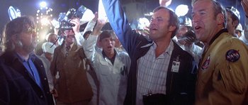 Movie still from “The Man Who Fell to Earth” (1976), directed by Nicolas Roeg – A group of people standing in a room; Medium shot, Low angle