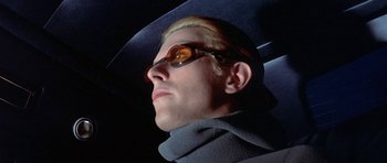 Movie still from “The Man Who Fell to Earth” (1976), directed by Nicolas Roeg – A man wearing sunglasses and a hat looking to his left; Close Up shot, Low angle