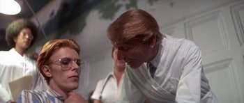 Movie still from “The Man Who Fell to Earth” (1976), directed by Nicolas Roeg – A man and a woman talking to each other; Close Up shot, Over the shoulder angle